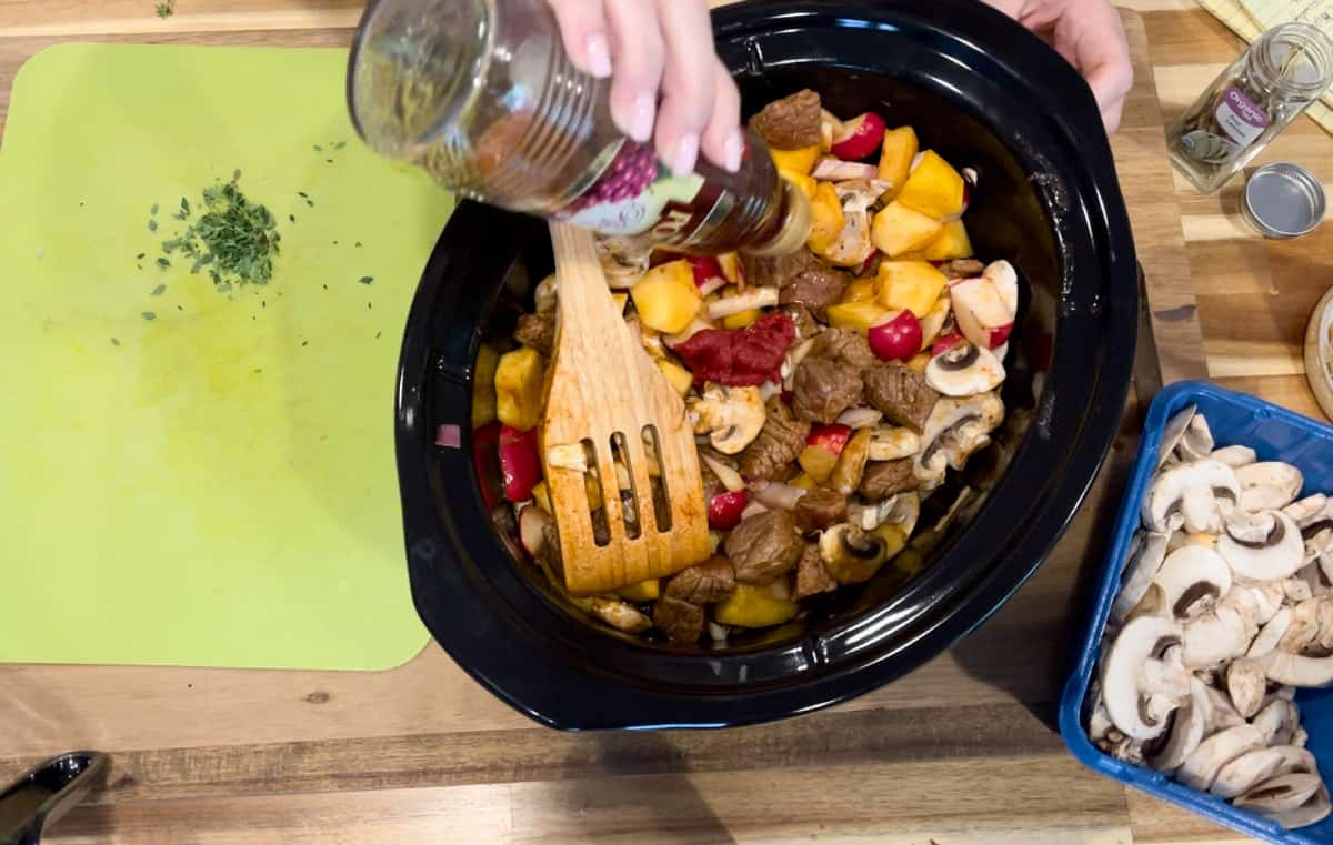 Adding red wine vinegar to black crock pot.