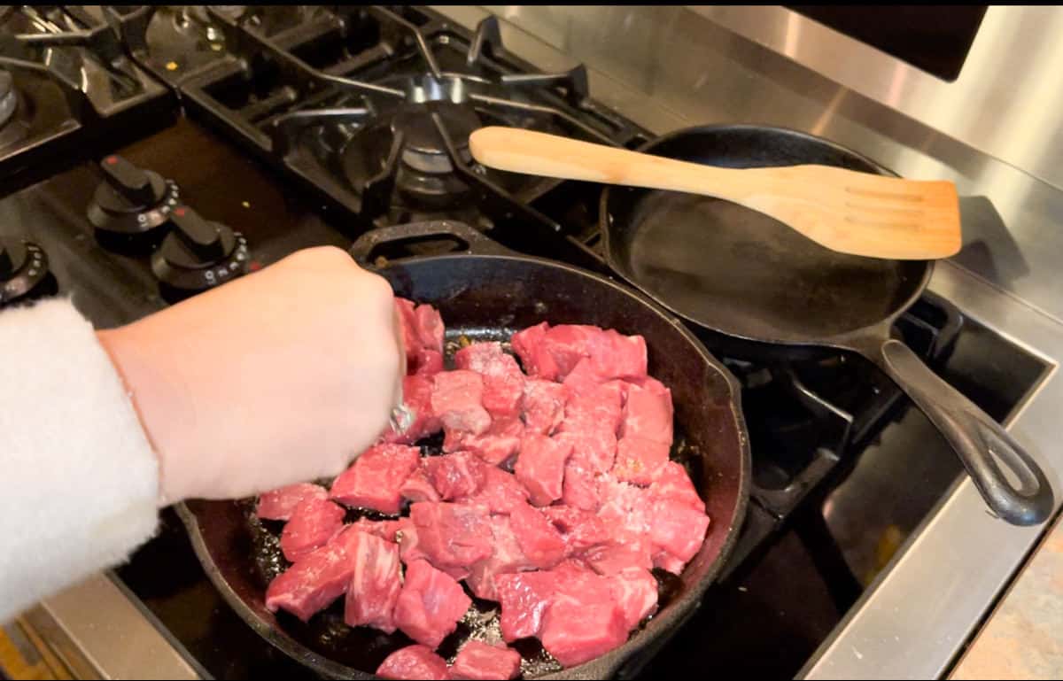 Adding salt to the beef.
