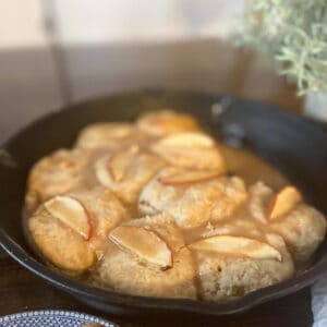 A cast iron pan of glazed apple biscuits.