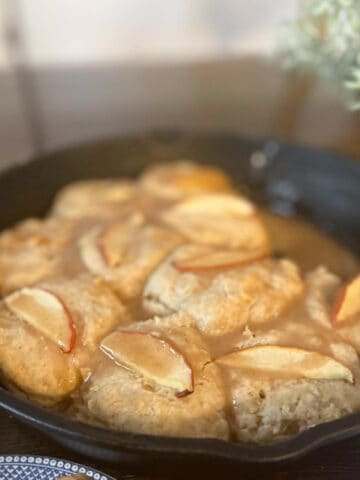 A cast iron pan of glazed apple biscuits.