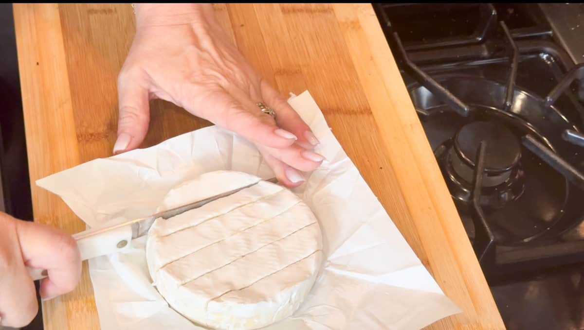 Cutting the top of the brie.