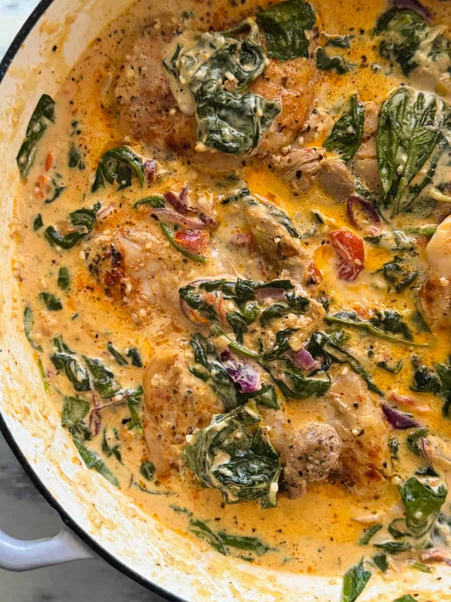 A pot full of creamy tuscan chicken thighs.
