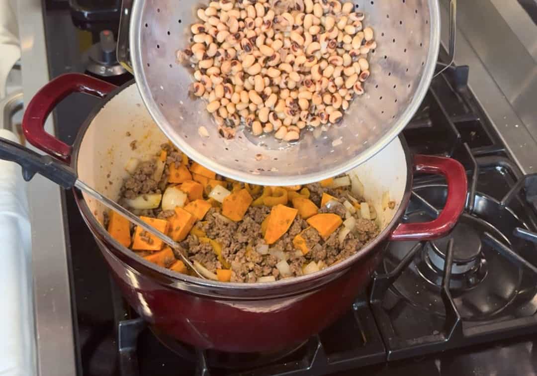 Adding drained and rinsed black eyed peas.