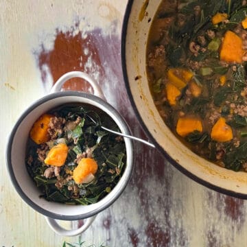 Bowl of sweet potato, black eye pea and collard soup next to the larger pot of soup.