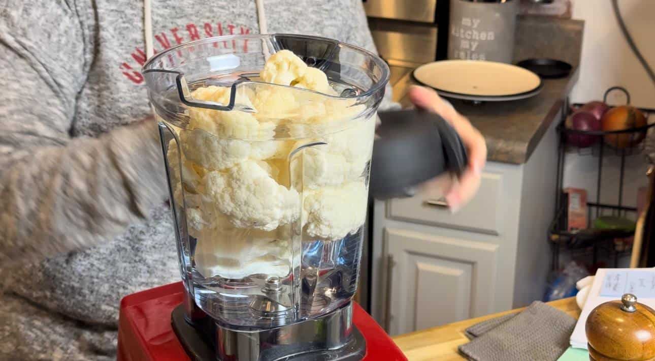 Cauliflower florets in a blender with water to break down.