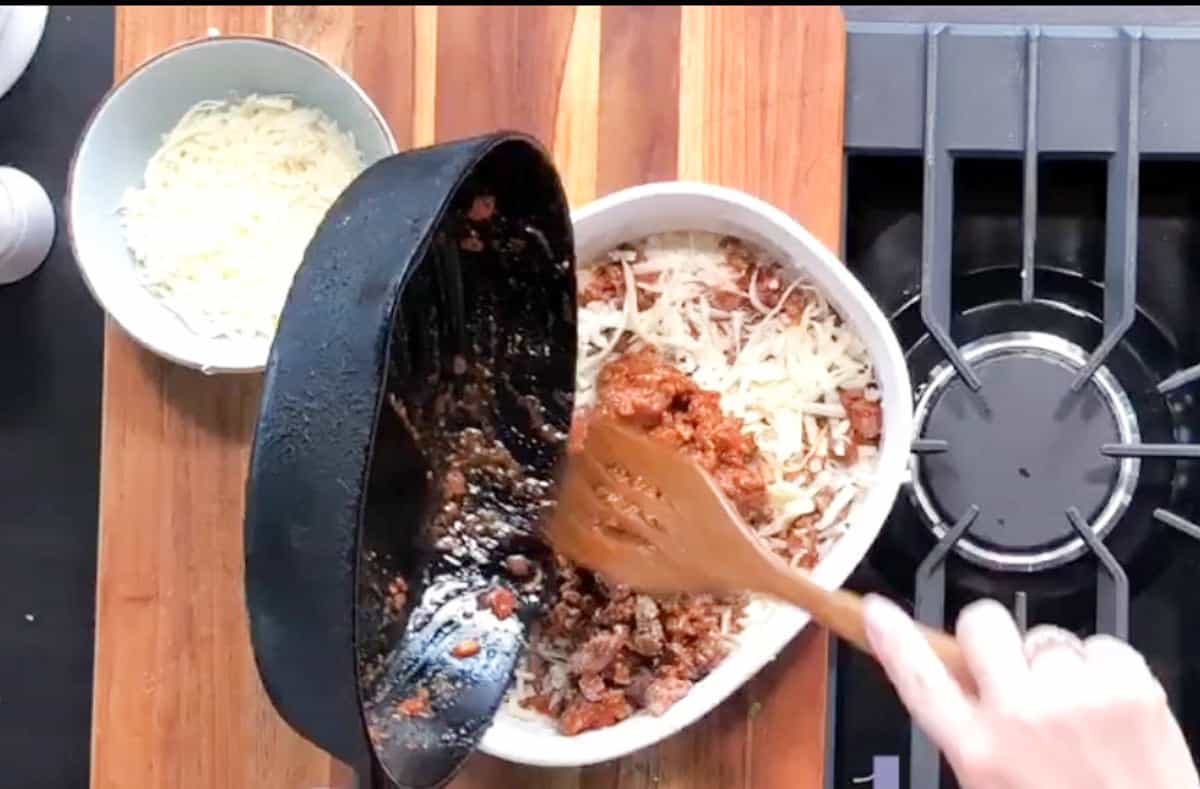 Adding a second layer of meat mixture.