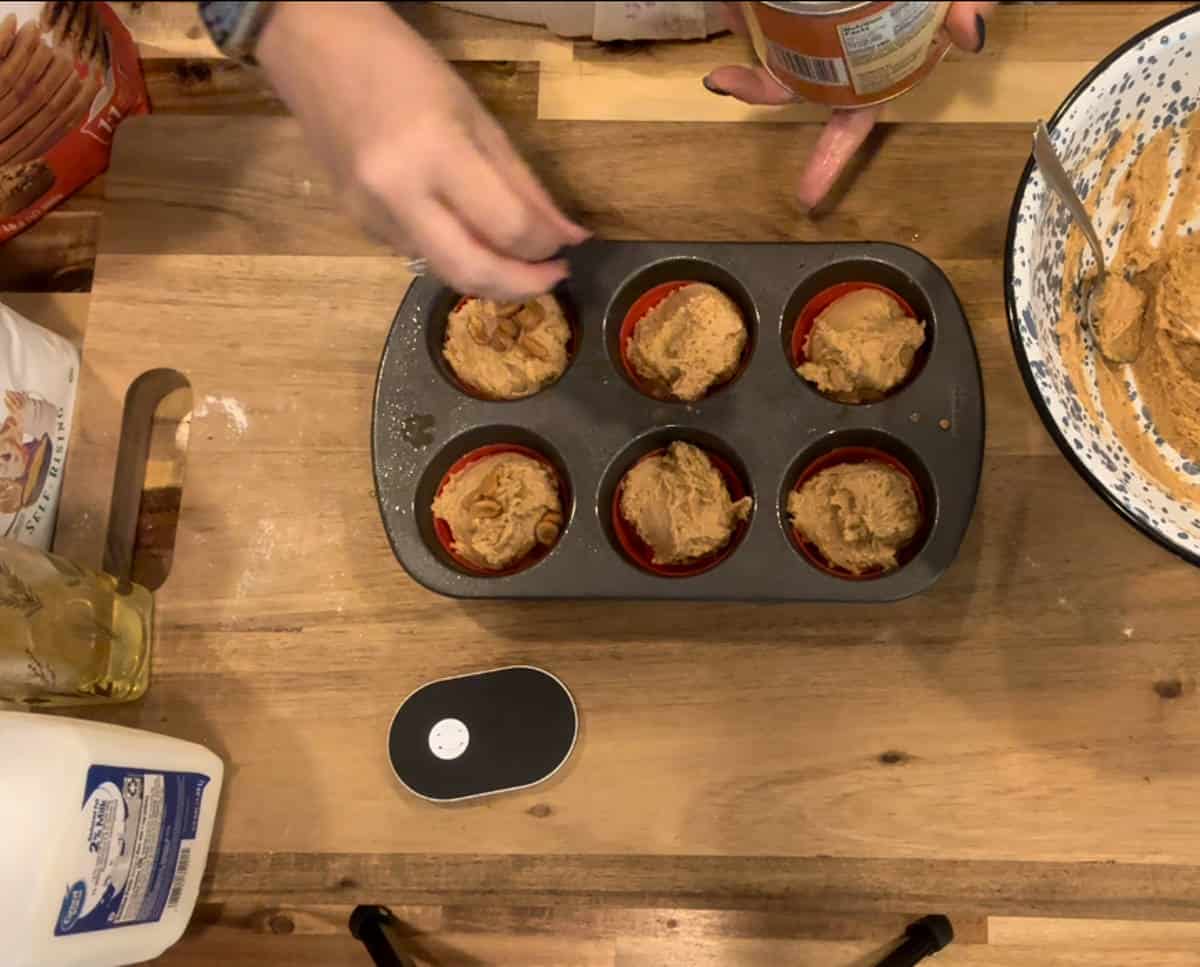 Garnishing the top of muffins with peanuts.