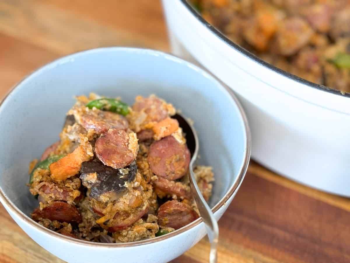 A blue bowl with a helping of chicken andouille hash.