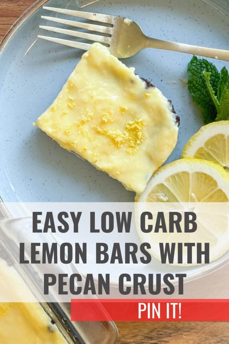 Image of a lemon bar with a pecan crust on a blue plate, accompanied by slices of lemon and a sprig of mint. the text "easy low carb lemon bars with pecan crust" and "pin it!" overlays the photo.