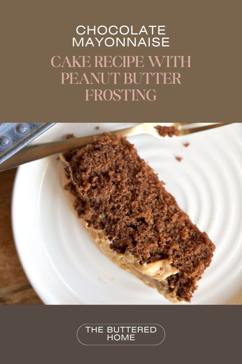A slice of chocolate cake with peanut butter frosting on a white plate. A knife rests beside the cake. Text above reads "Chocolate Mayonnaise Cake Recipe with Peanut Butter Frosting" and "The Buttered Home" at the bottom.