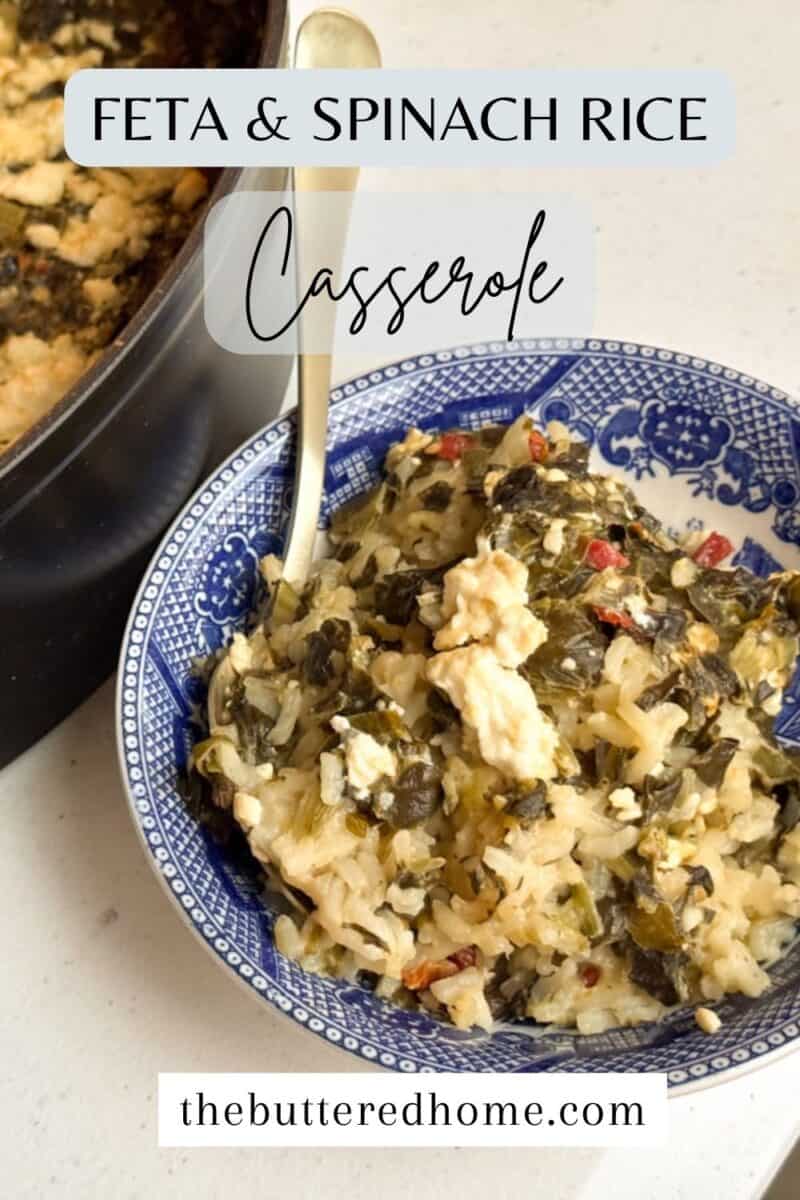 A blue and white plate filled with feta and spinach rice casserole, featuring visible chunks of feta and leafy greens. A spoon is placed in the dish. A black pot with more casserole is partially visible in the background. Text reads "Feta & Spinach Rice Casserole".
