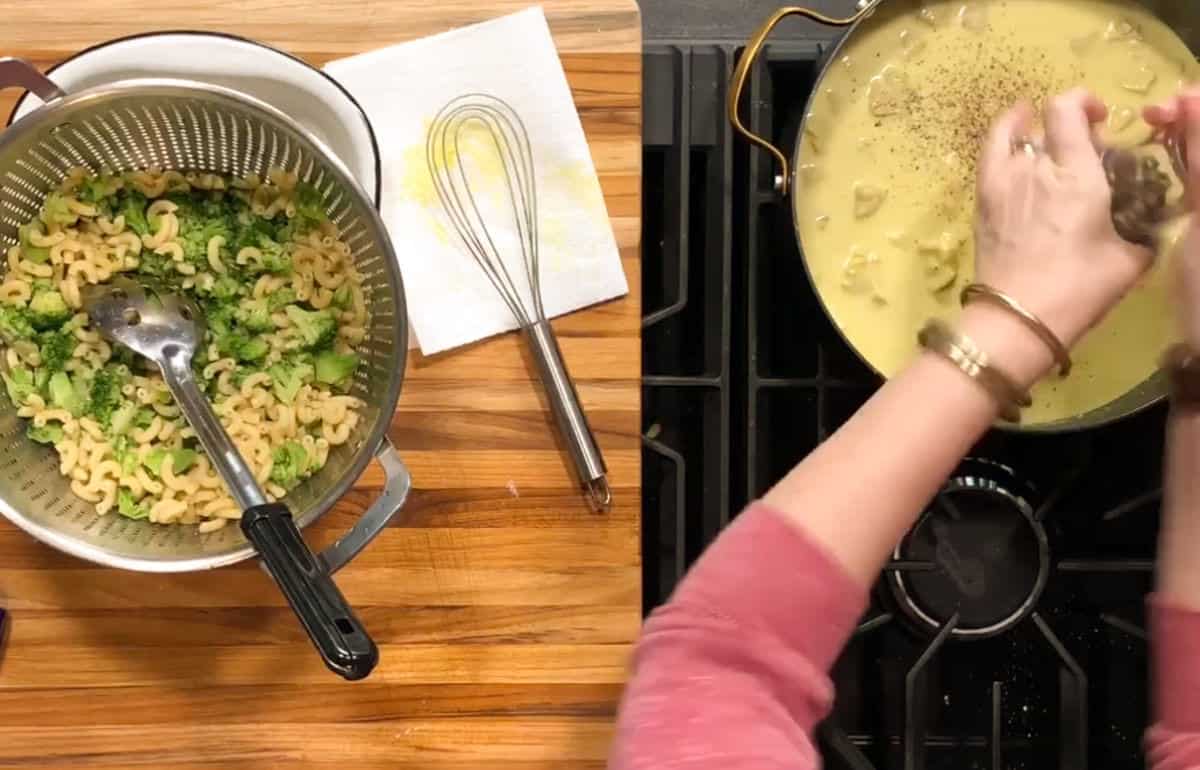 A strainer with cooked pasta and broccoli sits on a wooden counter beside a whisk and paper towel. Nearby, hands break food into a pot of yellow sauce on a stove.