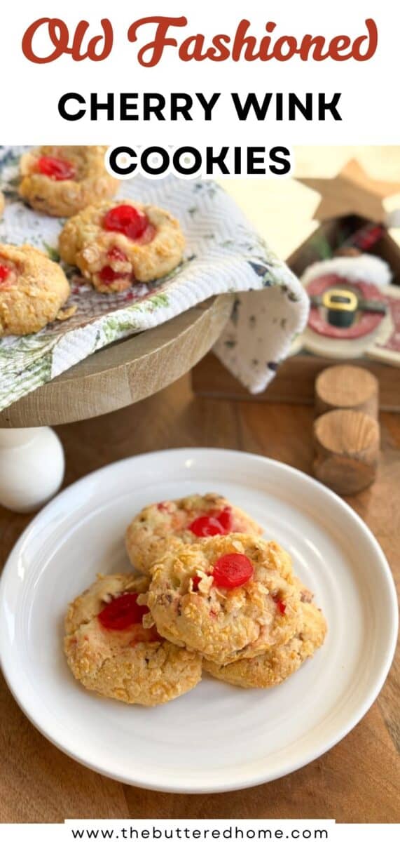 A white plate holds three cherry wink cookies topped with red cherries. More cookies are displayed on a wooden cake stand covered with a cloth. A decorative Santa figure is visible in the background. Text reads: "Old Fashioned Cherry Wink Cookies.